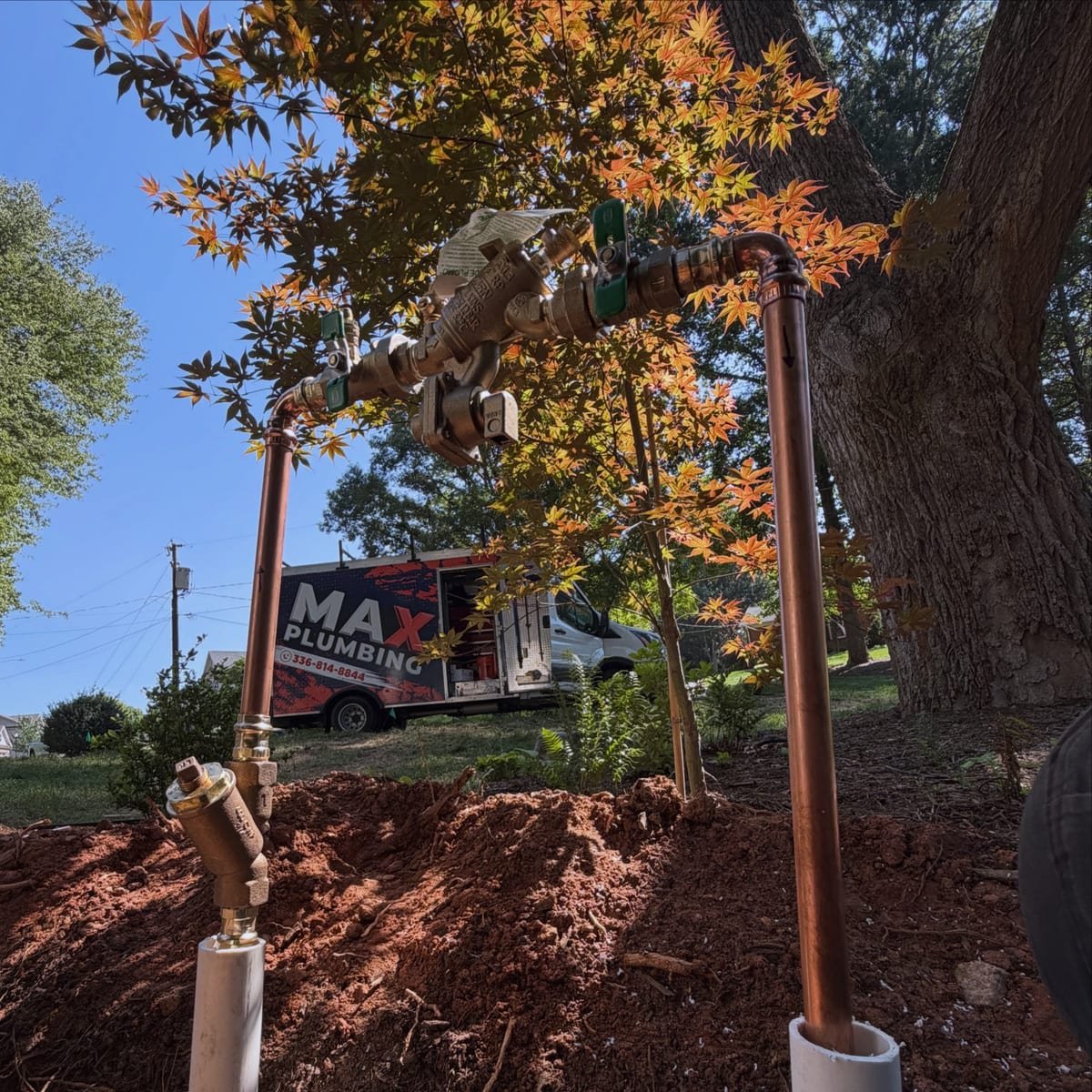 New copper backflow preventer with Zurn shutoff valves on a concrete irrigation pad