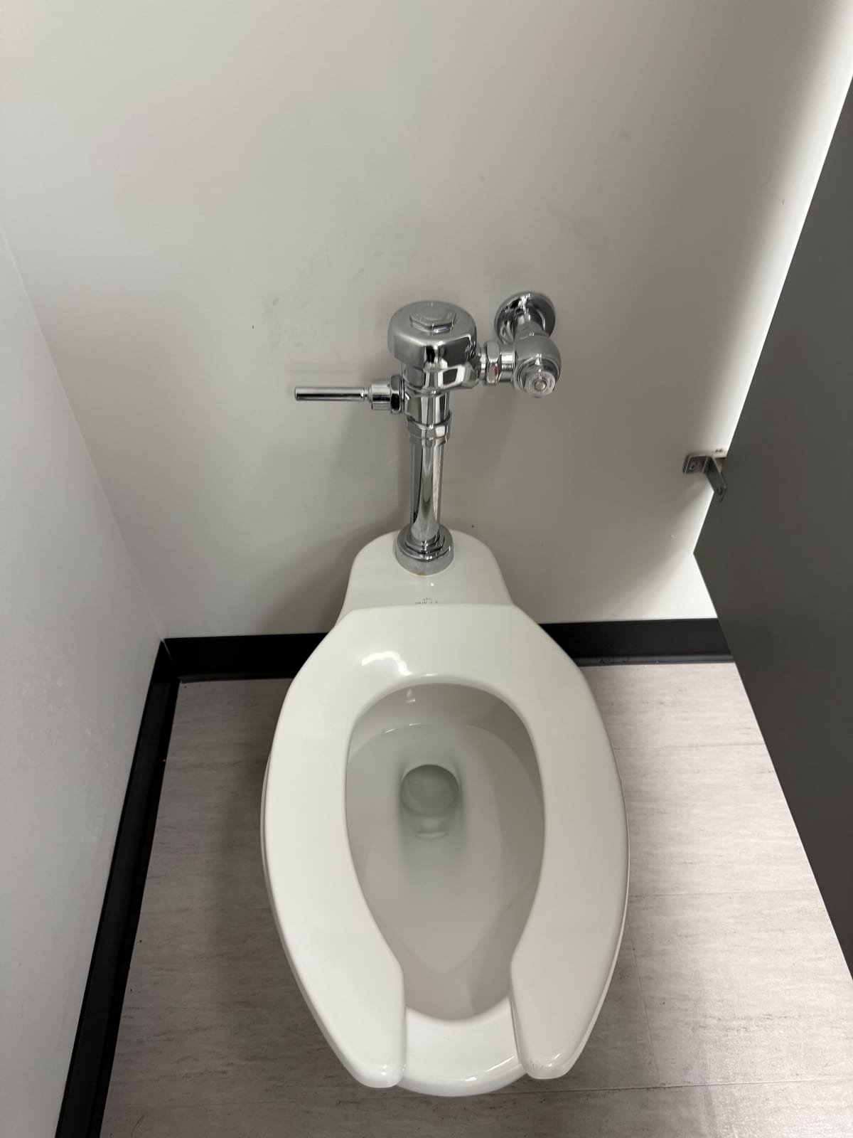 Commercial flushometer toilet installed in a business restroom