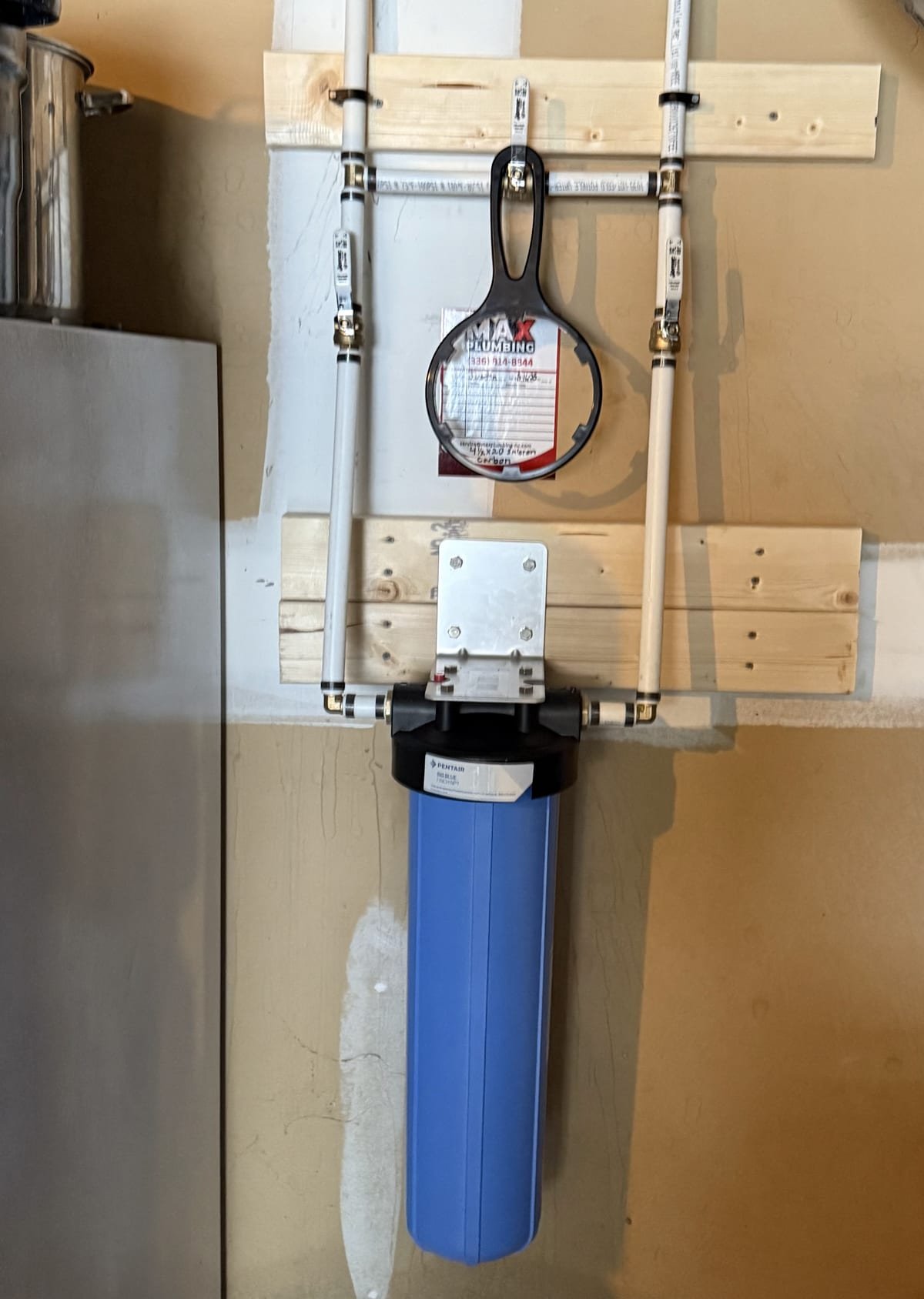 Compact inline water filter installed in a tight utility space