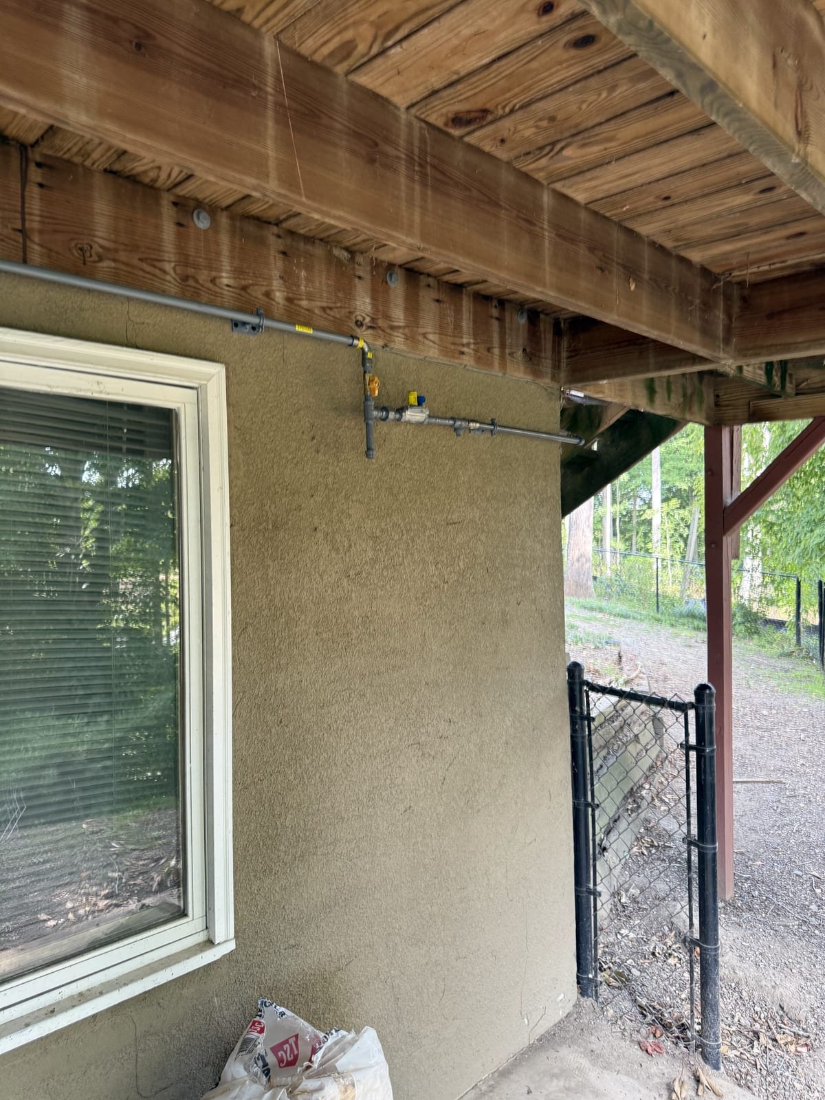 Gas line installation routed through a structure to an appliance connection