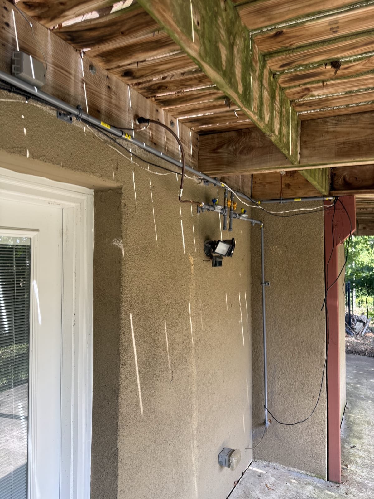 New black iron gas line installed and supported along a wall