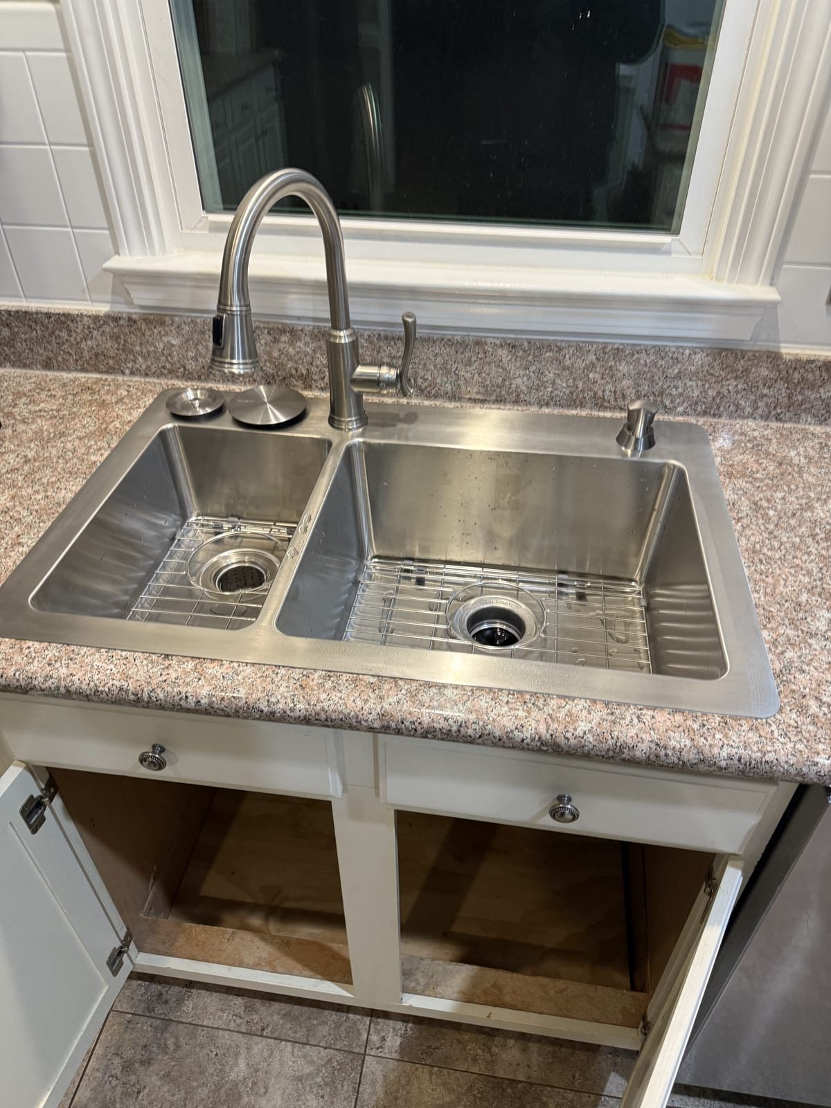 New kitchen sink installed with faucet and drain plumbing