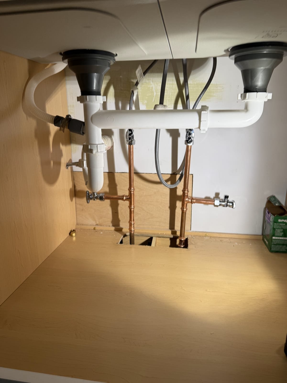 Kitchen sink drain assembly plumbed under the cabinet