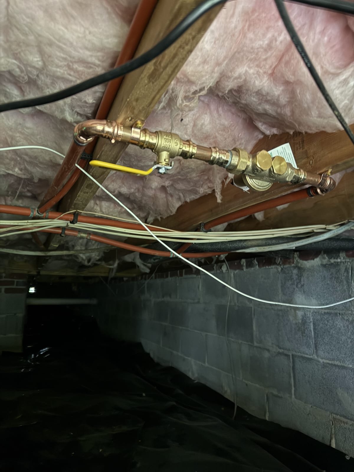 Pressure reducing valve installed on piping in a crawl space