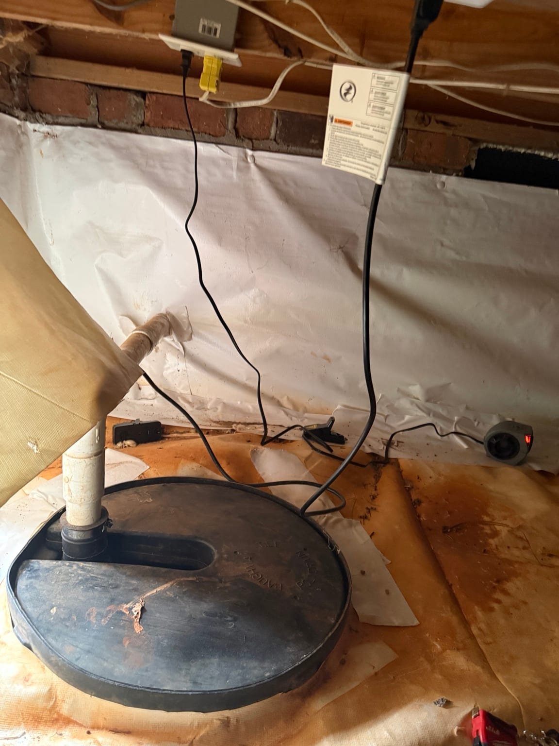 Sump pump basin lid and discharge piping installed in a crawl space in Clemmons, NC