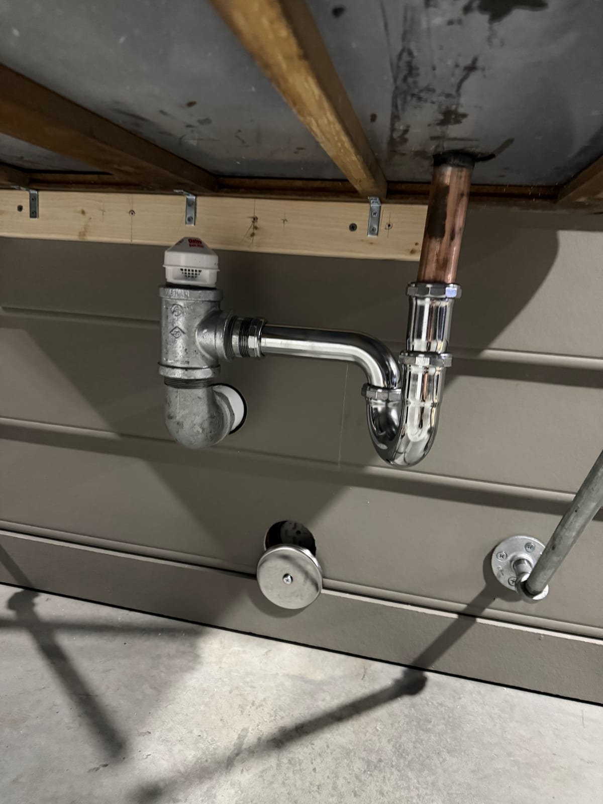 Custom-fabricated sink drain assembly installed under a basin