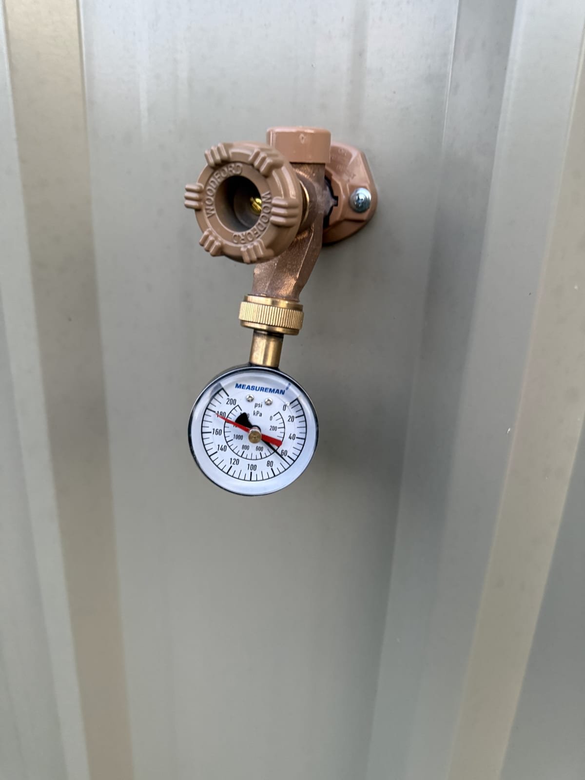 Water pressure gauge attached to a hose bib to measure system pressure