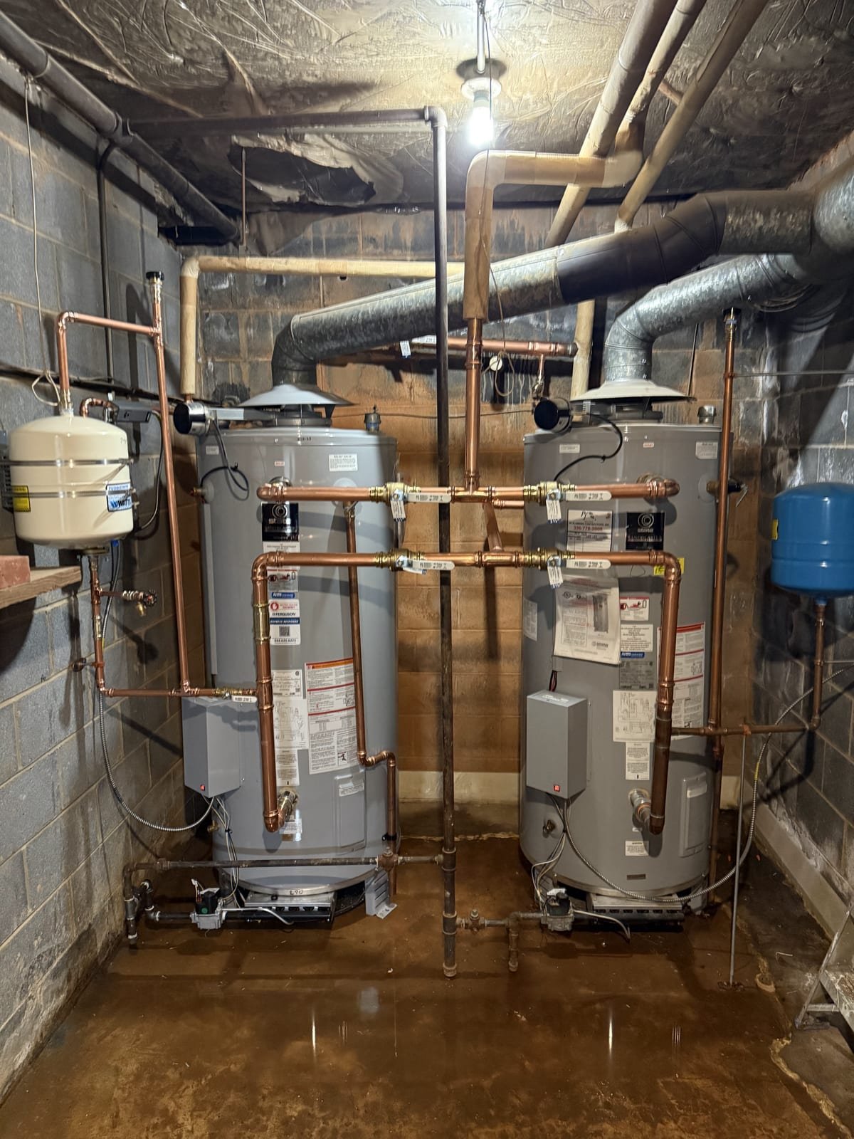 Bank of commercial water heaters installed with common venting and piping