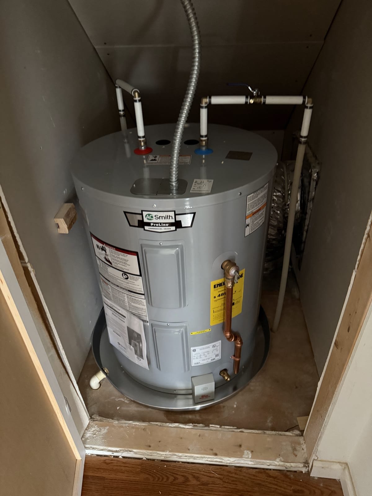 Electric water heater installation with expansion tank mounted above
