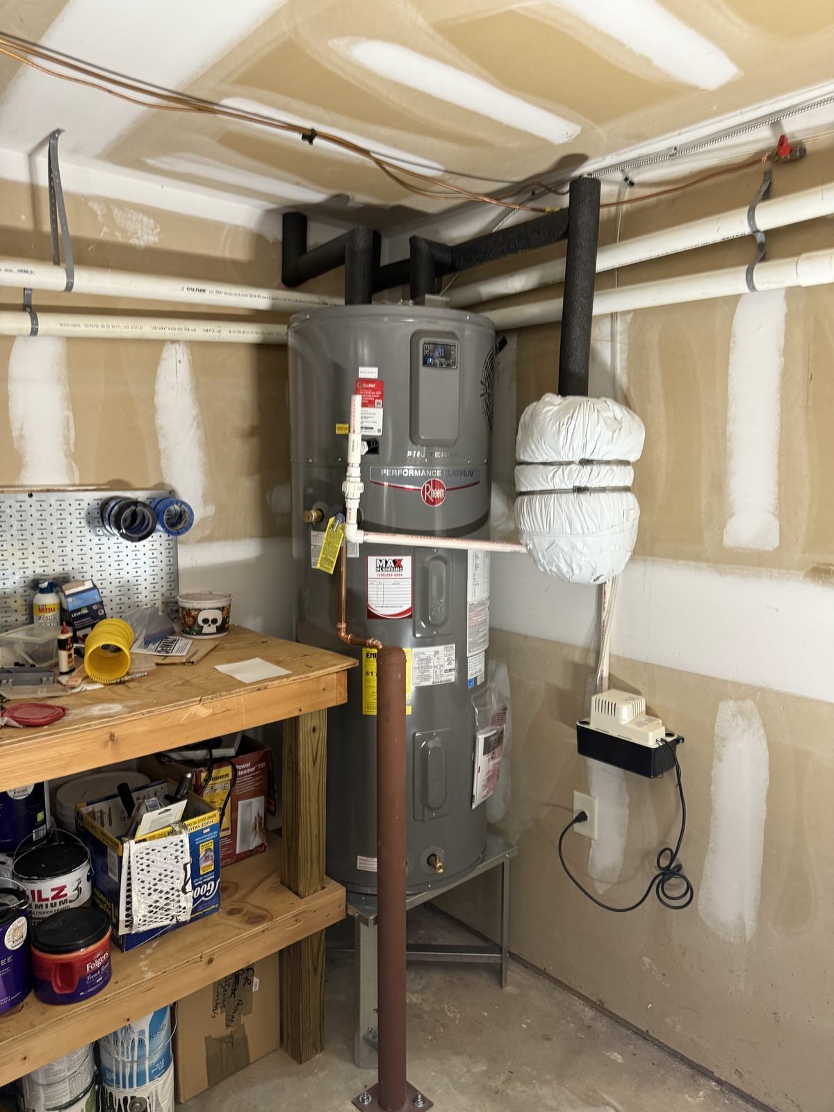 Hybrid heat-pump water heater installed with condensate drain connected