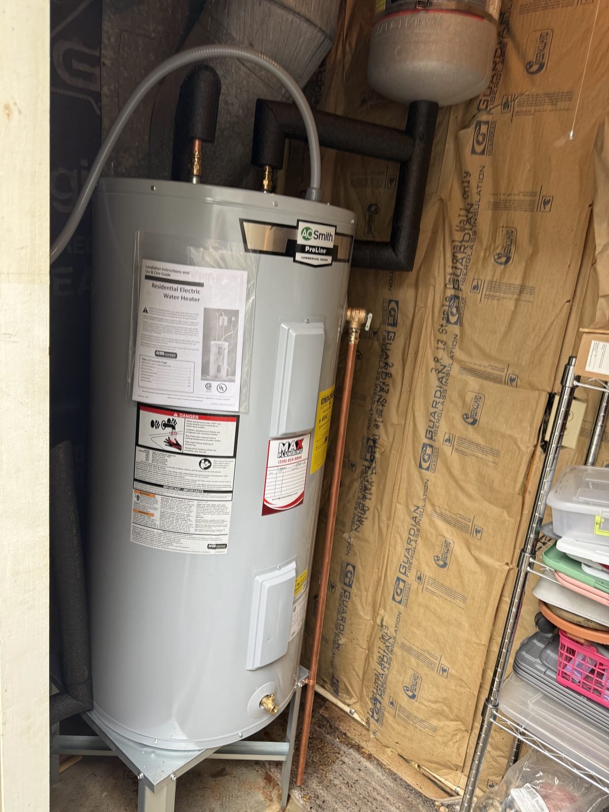 Electric tank water heater installed with flexible supply connectors and a drain pan