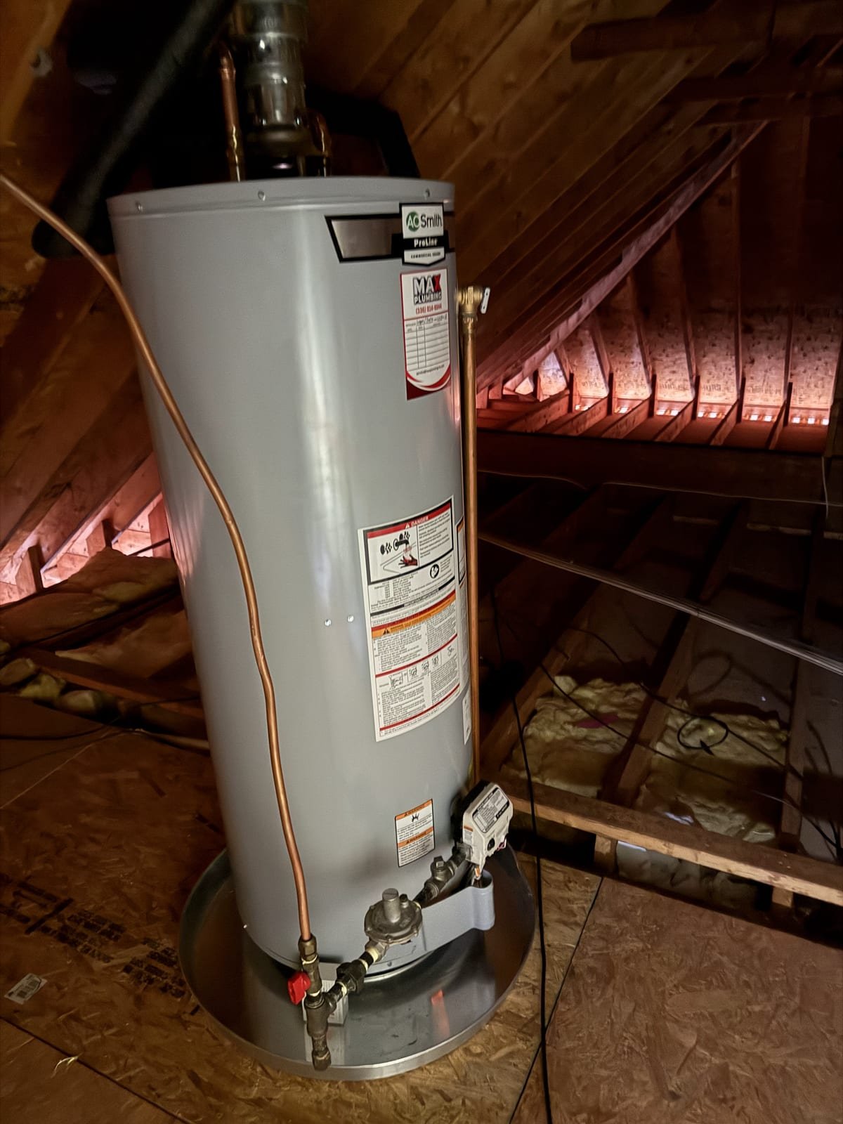 Gas water heater installed in an attic space with a drain pan beneath