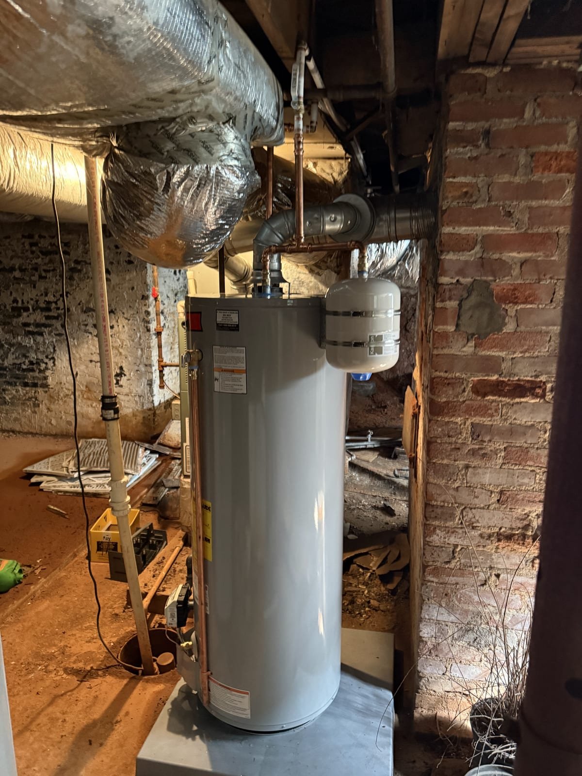 Gas water heater installed in a basement with gas line and venting connected