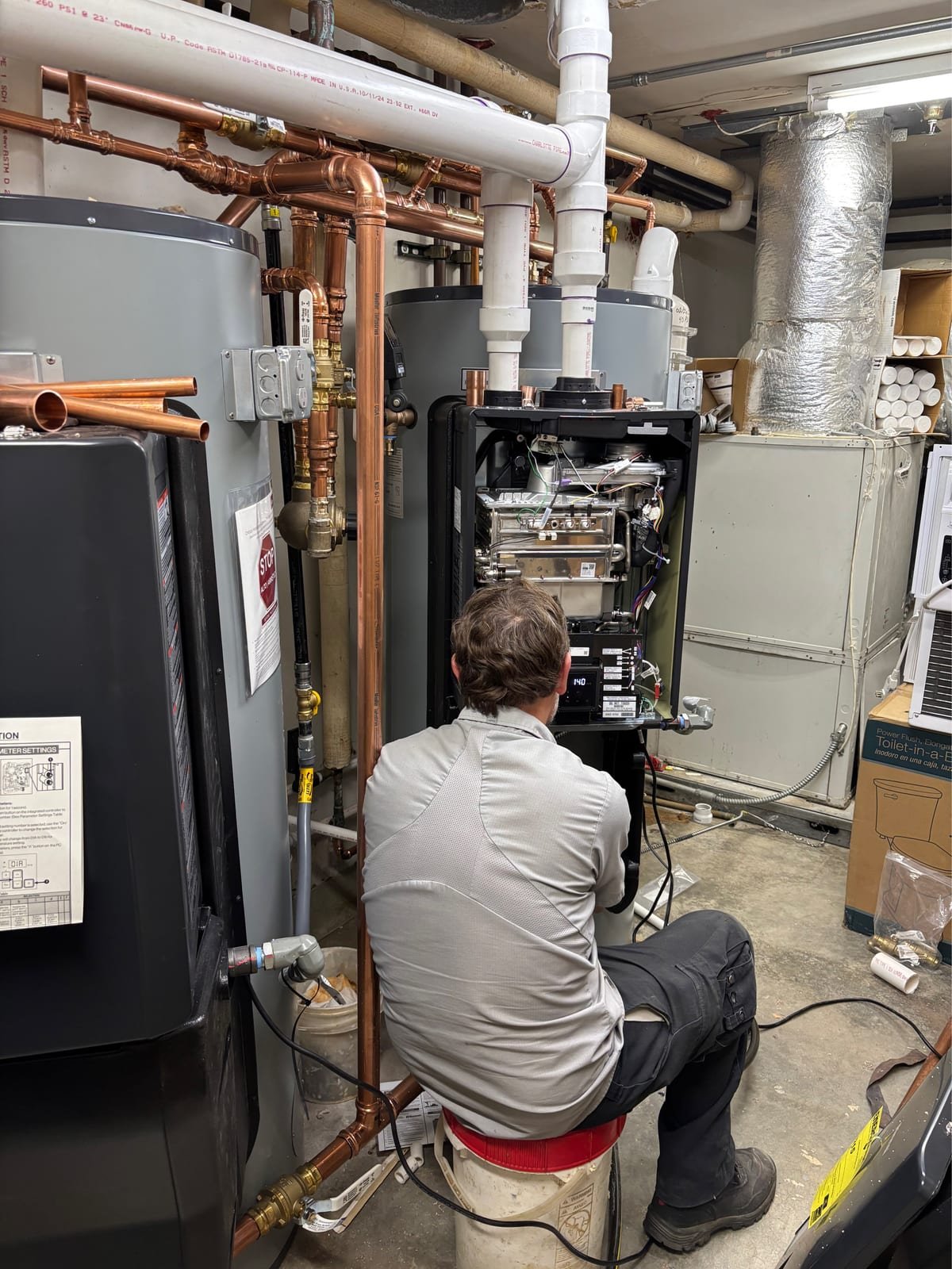 MAX Plumbing technician servicing a Rinnai Demand Duo water heater