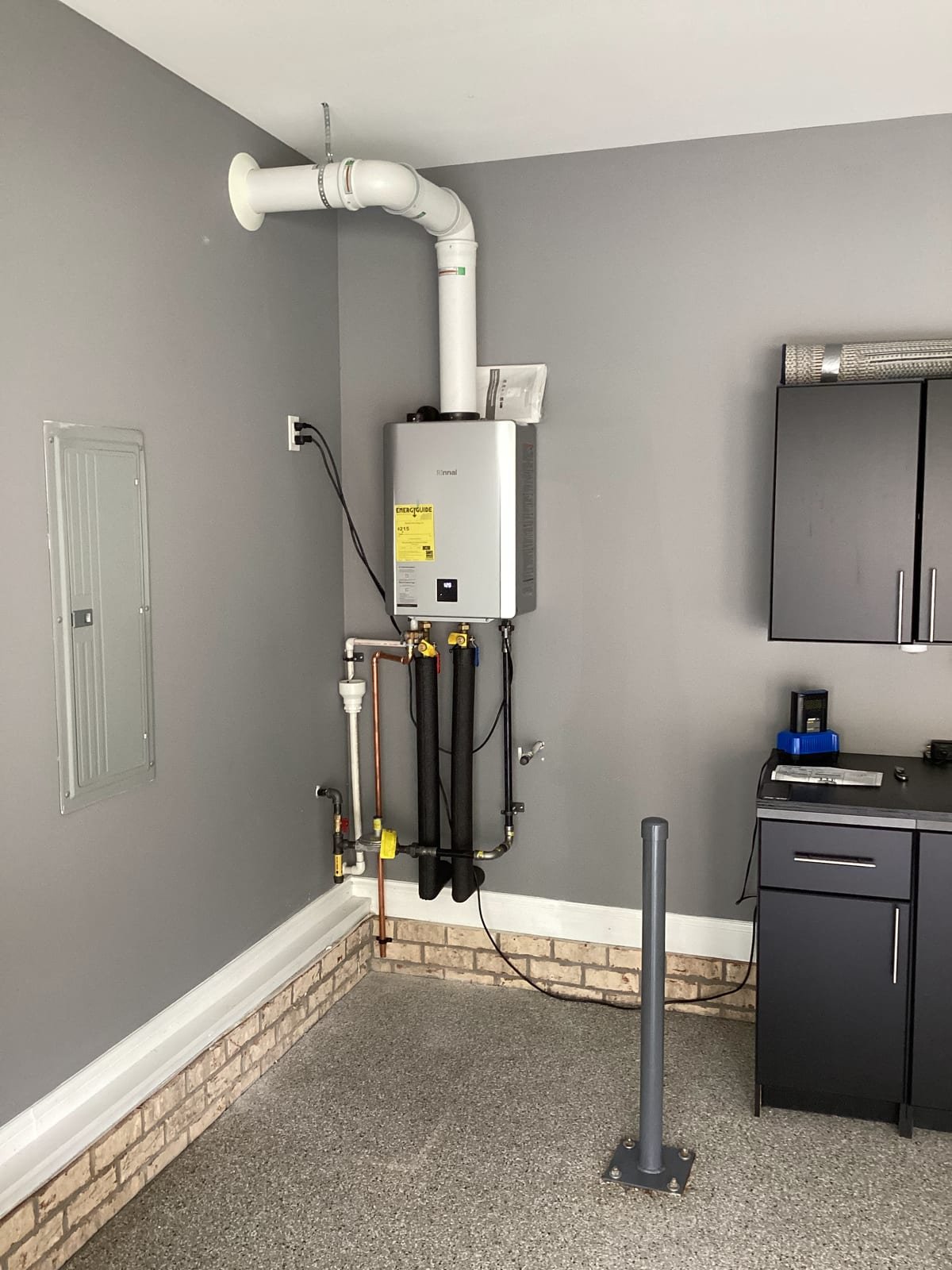 Finished tankless water heater installation with symmetrical copper piping and shutoff valves