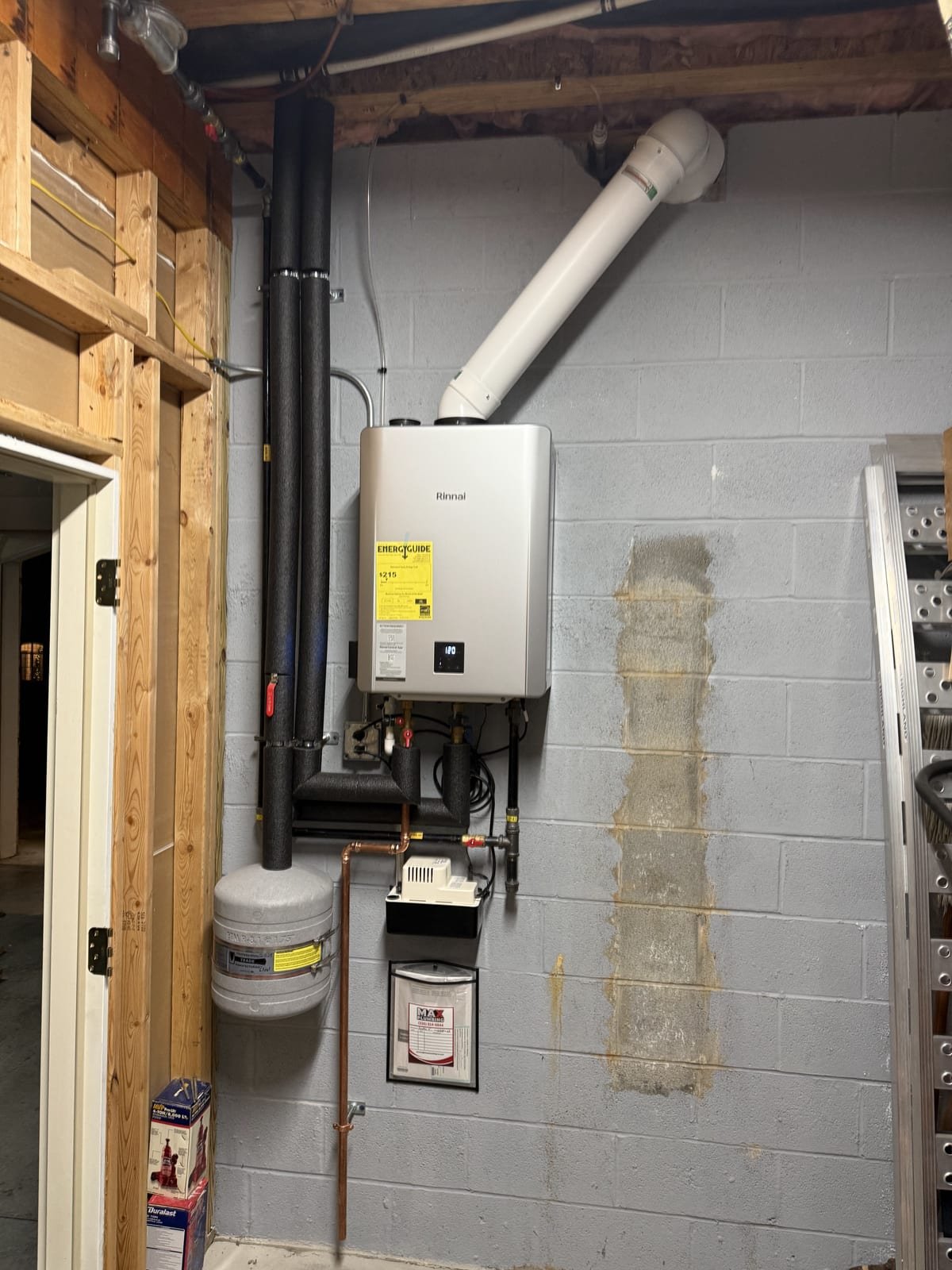 Tankless water heater installed in a utility space with gas and water connections