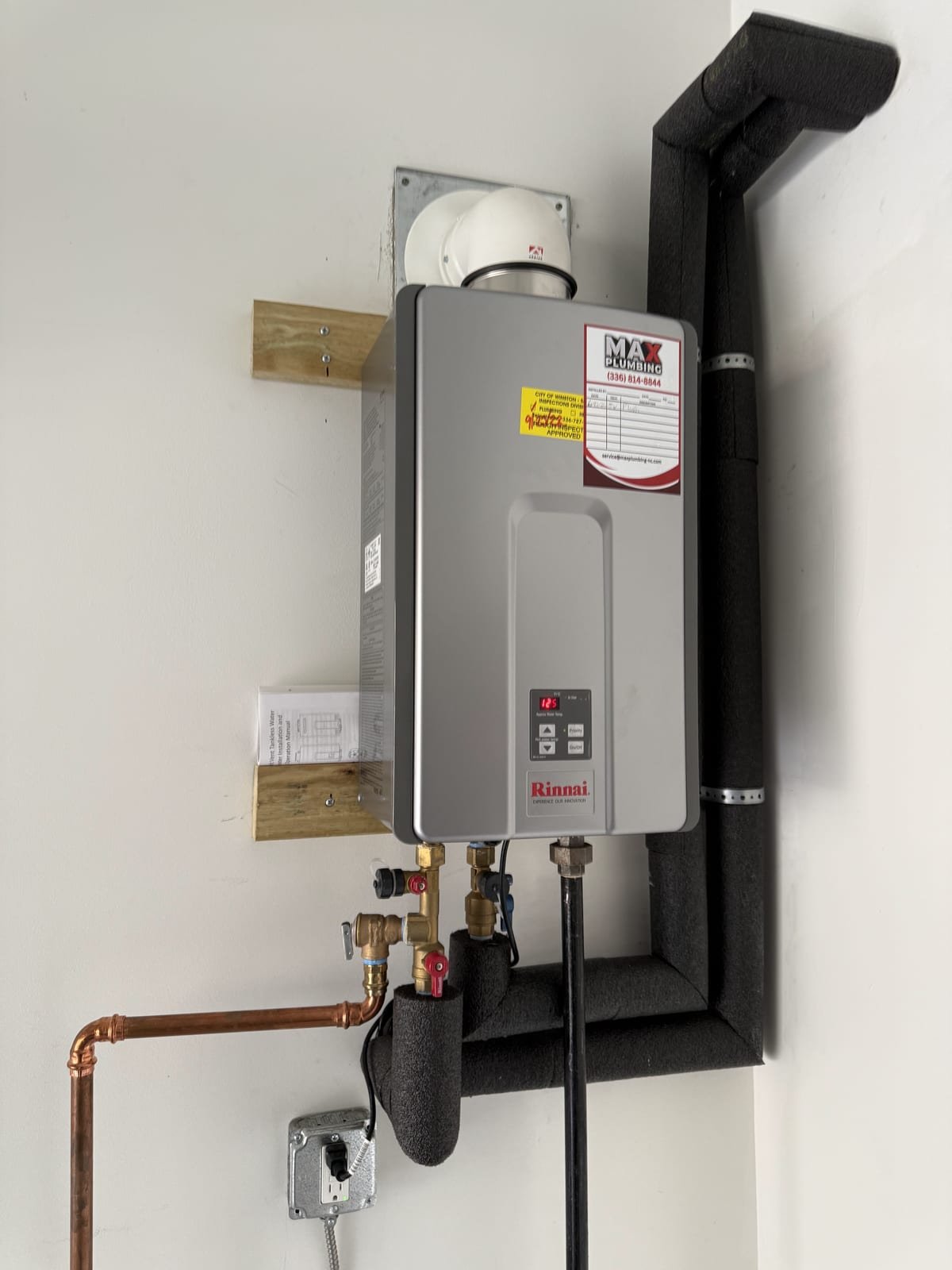 Tankless water heater unit mounted and piped for service