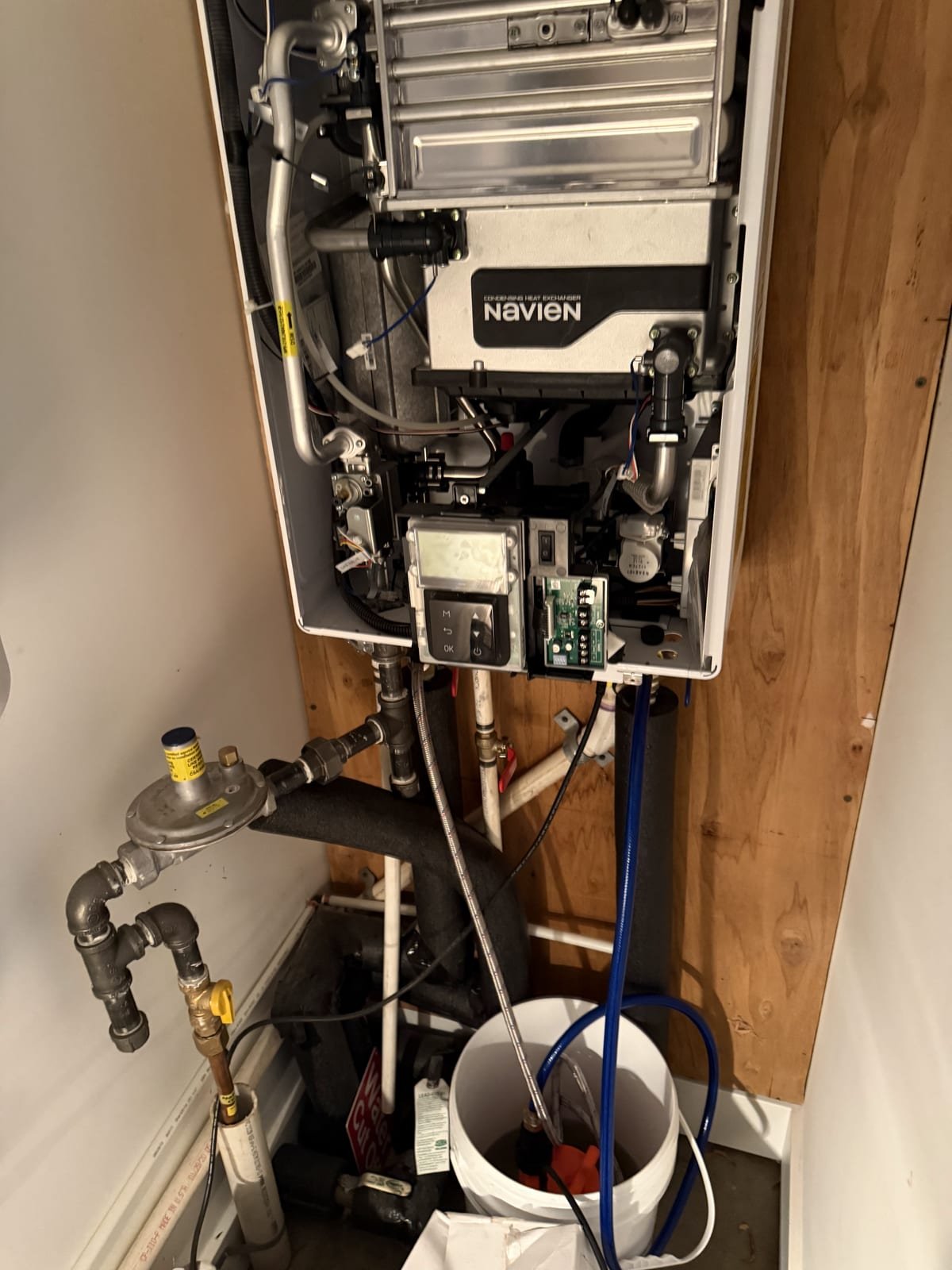 Technician performing a descaling service on a tankless water heater