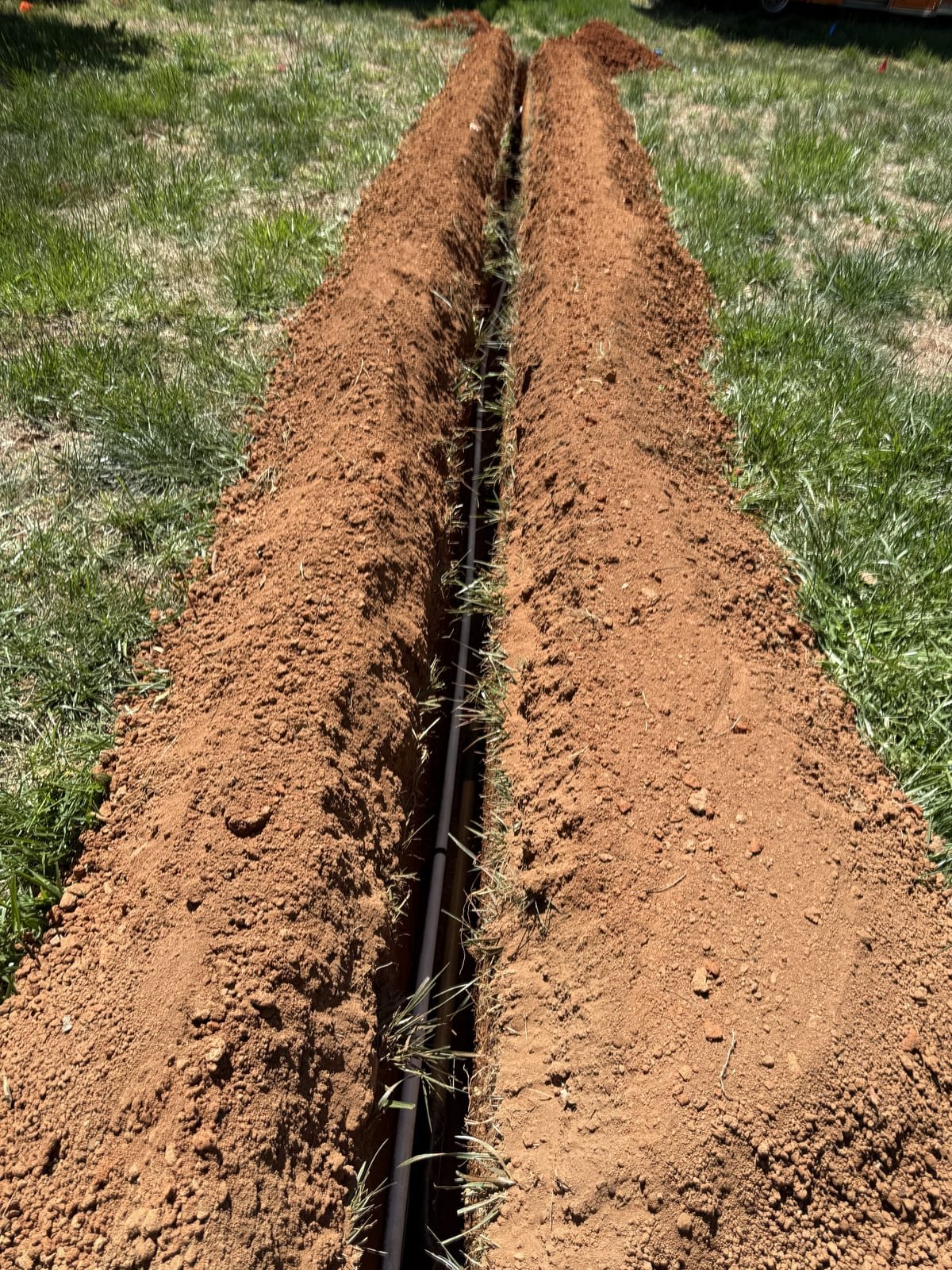 Excavated trench with new water service pipe laid in the bottom